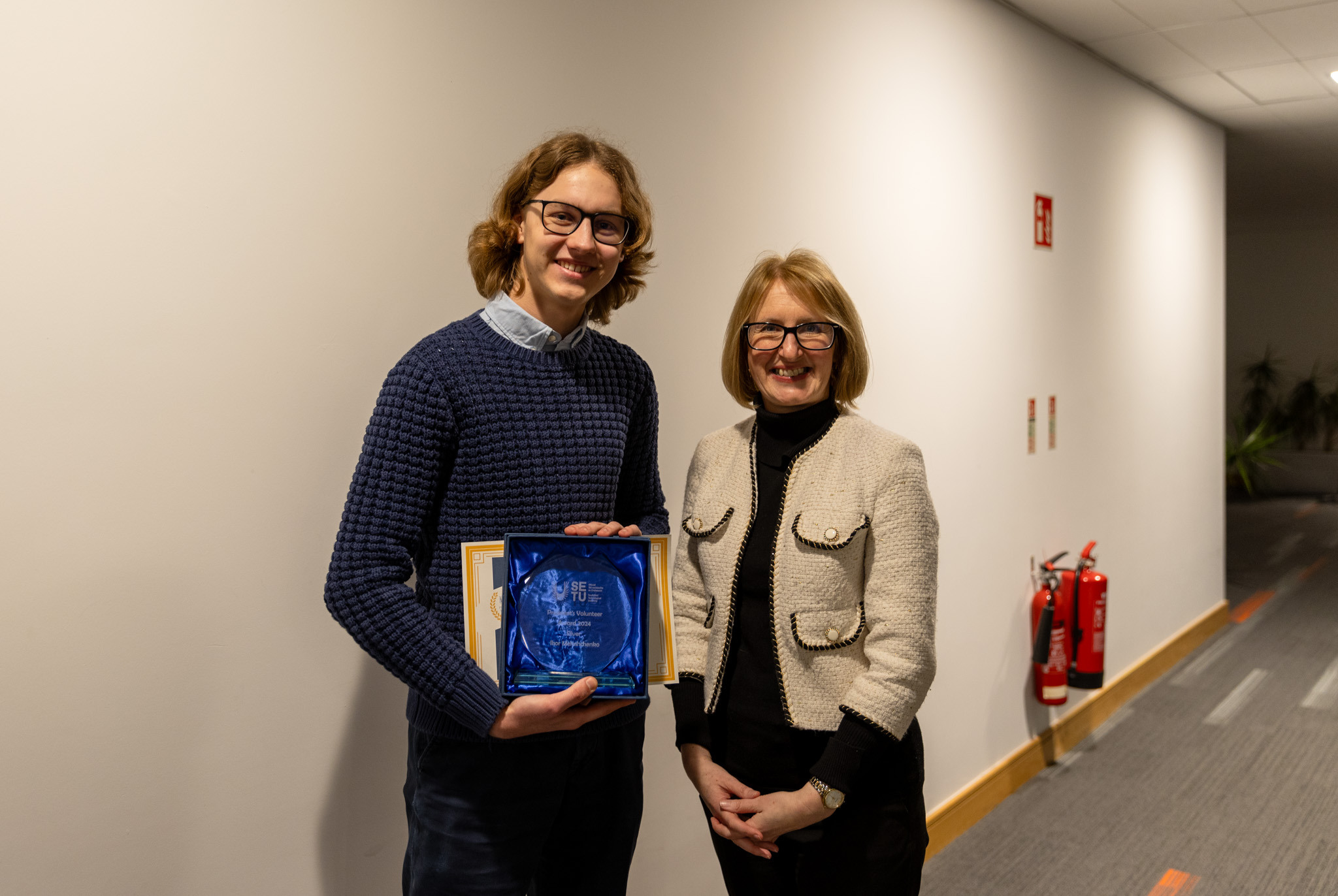 Two individuals standing side by side, one with a President’s Volunteer Awards